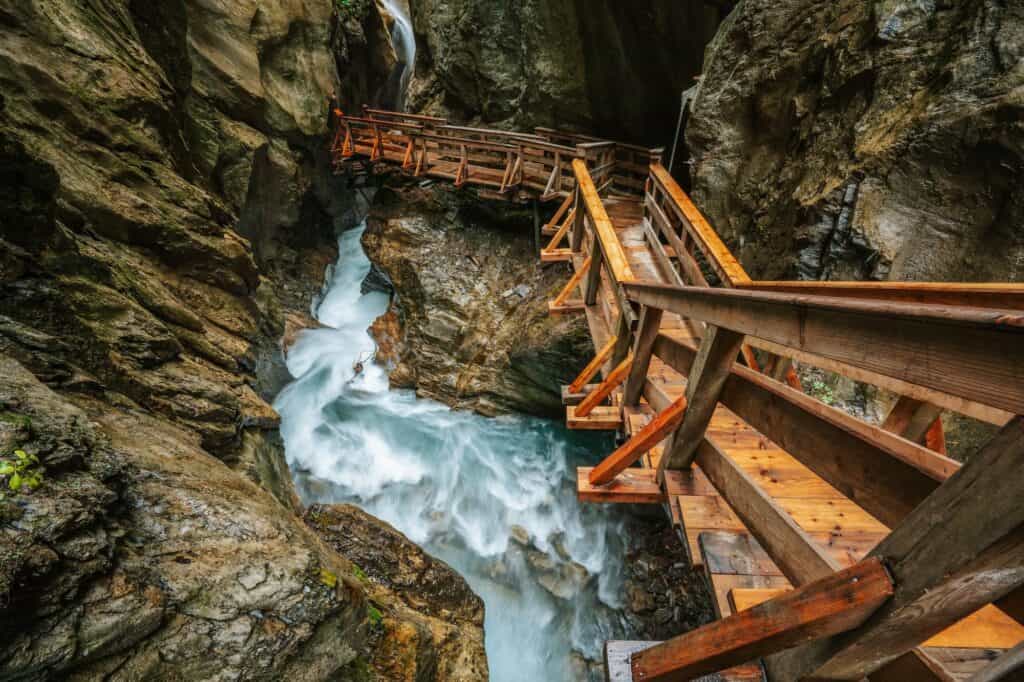 Wooden hike trail path inside a gorge with bue mountain river, Sigmund Thun Klamm, Kaprun, Austria